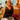 Woman in a black lace dress at a cafe holding the Coral Peek-A-Boo Clutch by Hadley Pollet, red leather over black