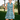 Smiling woman on a golf course wearing the Cyan Waves Zinnia Sleeveless Tennis Dress by Hadley Pollet with teal waves