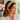 Smiling woman in a white lace blouse wearing the Green Zinnia Headband by Hadley Pollet, pink zinnias on green