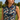 Close-up of the Navy Wave Zinnia Golf Sleeveless Top by Hadley Pollet with red zinnias and a striped zip collar on a course