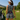 Back view of a golfer by a cart wearing the Navy Wave Zinnia Golf Sleeveless Top by Hadley Pollet with a matching skirt