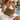 Woman in a white slip dress by a pool holding the Olive Lovebug Clutch by Hadley Pollet with bee and medallion print
