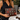 Woman in black at a marble café table holding the Red Lovebug Clutch by Hadley Pollet with beetles and red florals