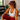 Woman in a white sports bra in a home gym wearing the Red Zinnia Dot Headband by Hadley Pollet, red with blue dots