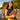 Woman by the water wearing a Hadley Pollet Stained Glass silk scarf as a head scarf, holding the Watermelon Peek-a-Boo Clutch