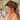 Smiling woman with a ponytail wearing the Zinnia Dot Headband by Hadley Pollet, charcoal with pink dots